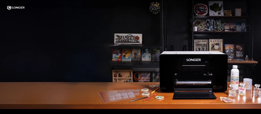 La impresora UV Longer ePrint de doble cabezal en un taller, rodeada de las fundas de móvil, botellas y etiquetas que decora